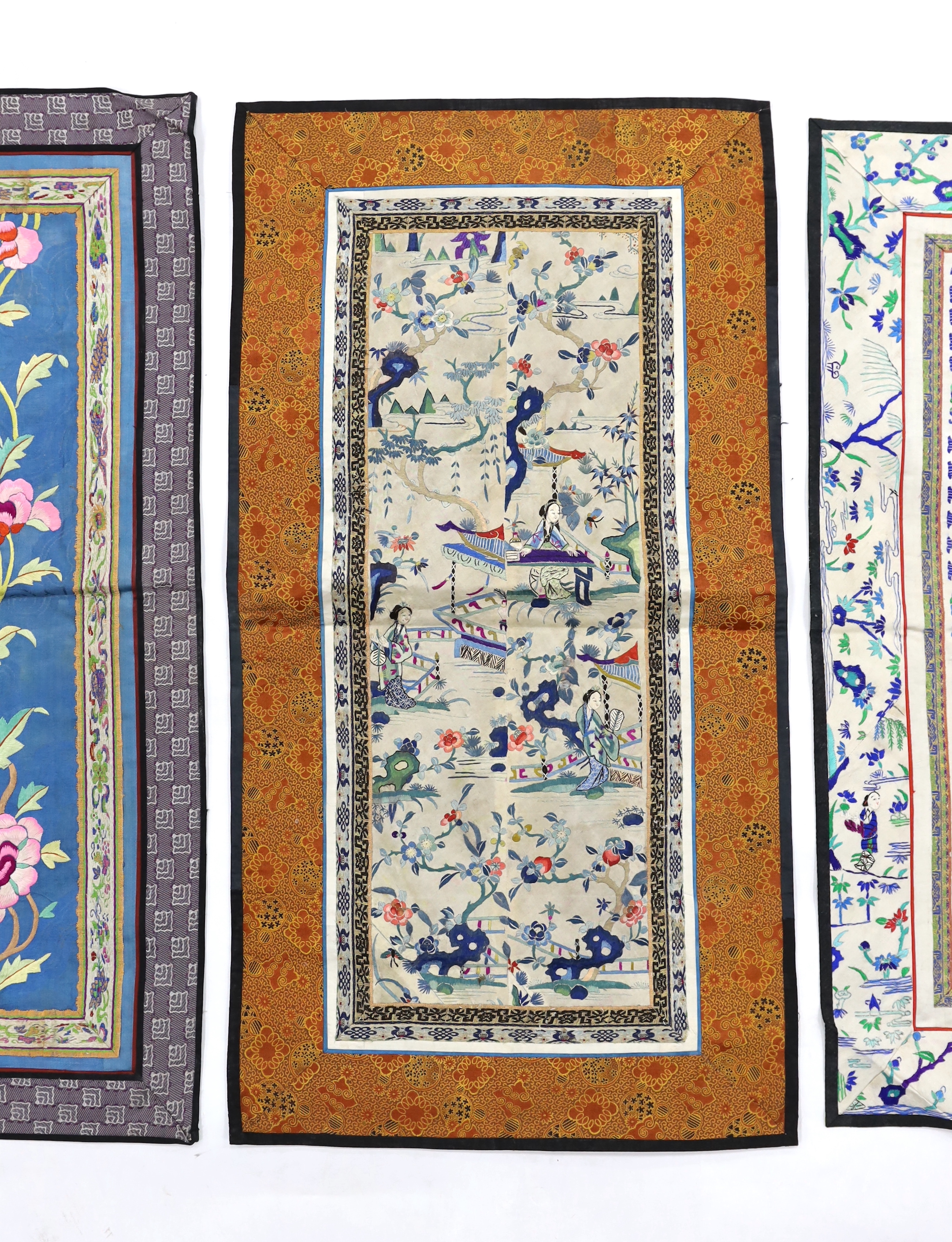 Four pairs of Chinese sleeve bands, two embroidered with figures on cream silk, a pair of floral embroidered on gold silk and the other polychrome flowers on blue silk, three with brocade borders, two largest 69cm high x